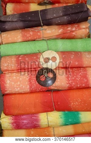 Batik Cloth Cloth For Sale Rolled Up In Market. Balinese Art And Culture. Close Up Of Rolled Colorfu