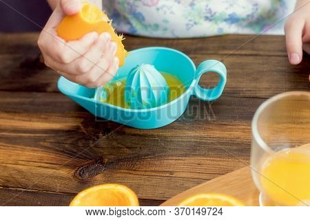 The Process Of Making Orange Juice In The Home Kitchen. A Glass Of Fresh Juice. Otanges On The Table