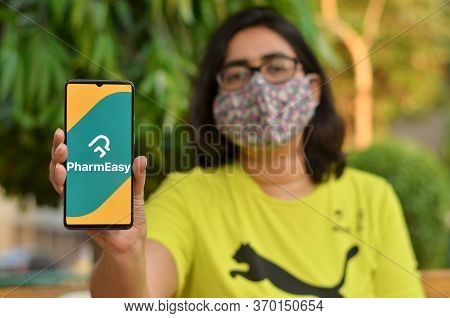 New Delhi, India, 2020. Girl Wearing Mask With Pharmeasy App On The Mobile Phone. Only Essential Ser