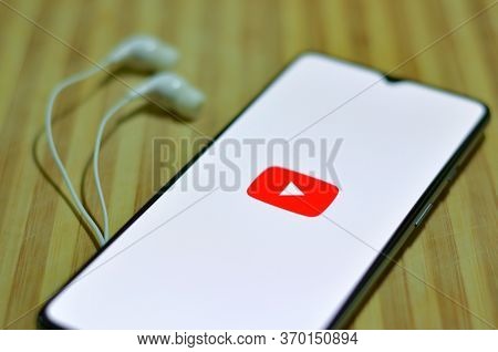 London, Uk, 2020. Flat Lay Of Youtube App Icon On The Smartphone Screen On Display And A Pair Of Ear