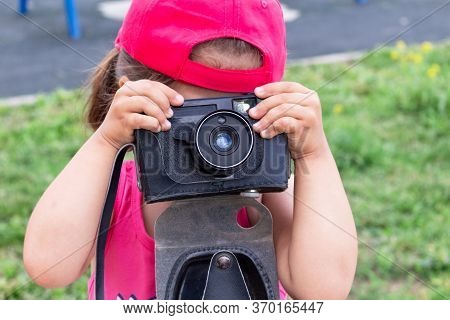 Little Girl Shooting Blog On Retro Photo Camera сlose Up.
