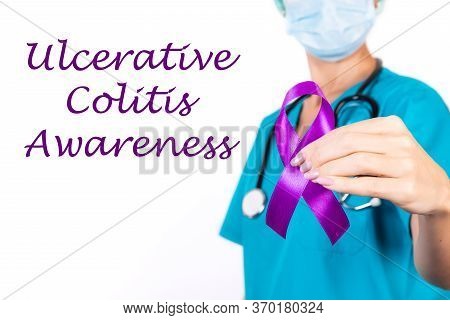 Ulcerative Colitis Concept. The Doctor Holds A Purple Ribbon In Her Hand As A Sign Of Awareness.
