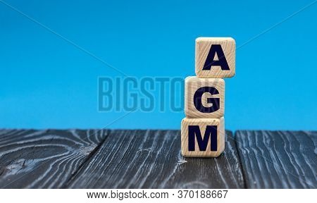 Concept Acronym Agm (absorbent Glass Mat) On Wooden Cubes On A Blue Background. Technology Concept