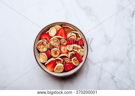 Trendy Home Breakfast With Tiny Cereal Pancakes With Piece Of Butter And Fresh Strawberries In The B