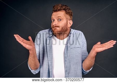 Maybe Yes Or No. Doubtful Redbearded Fashionable Guy Shrugs Shoulders In Bewilderment, Tries To Make
