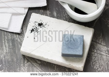 Handmade Soap With Activated Carbon On Marble, Carbon Powder And A Cotton Towel On A Gray Background