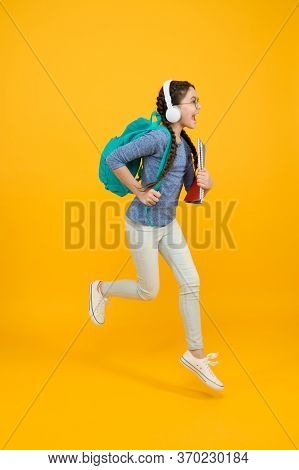 Full Of Energy. Energetic Child Run To School. Happy Girl In Motion Yellow Background. Childhood Ene