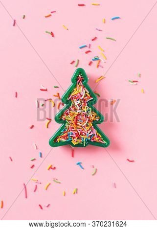 Christmas Celebration Flat Lay With Toy Christmas Tree And Sprinkle On Pink Background, Top View, Co