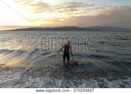 Banyuwangi, Indonesia - May 14, 2020 : A Woman Playing With The Dogs At Watudodol Beach Banyuwangi E