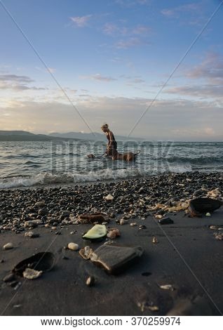 Banyuwangi, Indonesia - May 14, 2020 : A Woman Playing With The Dogs At Watudodol Beach Banyuwangi E