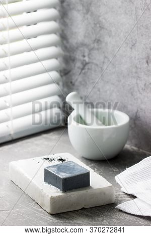 Handmade Soap With Activated Carbon On Marble, Carbon Powder And A Cotton Towel On A Gray Background