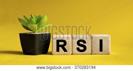 Rsi - Business Financial Concept On A Yellow Background. Wooden Cubes And Flower In A Pot.