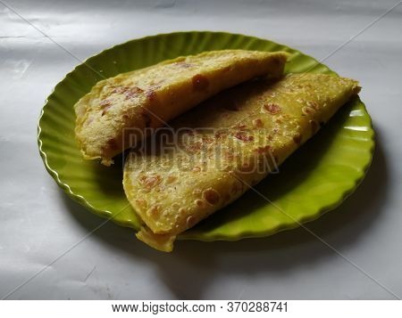 Group Of Yellow Color Traditional Dal Obbattu Or Holige In A Plate Isolated On White Background
