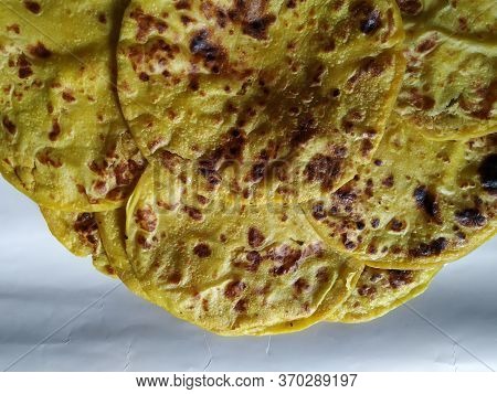 Closeup Of Yellow Color Traditional Dal Obbattu Or Holige In A Plate Isolated On White Background