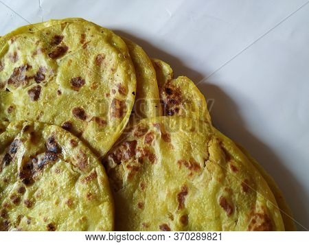 Closeup Of Yellow Color Traditional Dal Obbattu Or Holige In A Plate Isolated On White Background