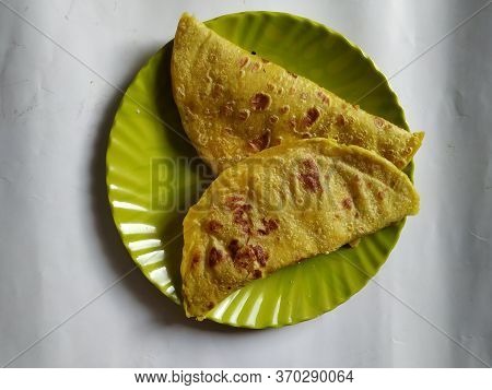 Closeup Of Yellow Color Traditional Dal Obbattu Or Holige In A Plate Isolated On White Background