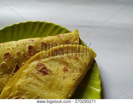 Closeup Of Yellow Color Traditional Dal Obbattu Or Holige In A Plate Isolated On White Background