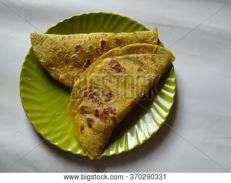 Closeup Of Yellow Color Traditional Dal Obbattu Or Holige In A Plate Isolated On White Background