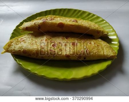 Group Of Yellow Color Traditional Dal Obbattu Or Holige In A Plate Isolated On White Background