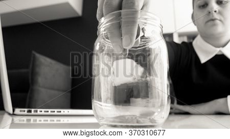 Black And White Portrait Of Beautiful Business Lady Dressed In Black Suit , Sitting At The White Tab