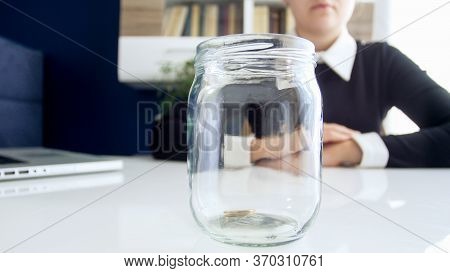 Closeup Image Of Business Lady Dressed In Black Dress , Sitting At The White Table On Which Is Locat