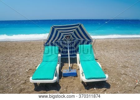 Two Sunbeds On The Sandy Beatch Against Sea. Sea Resort.