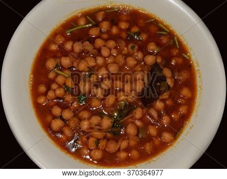 Top Angle Shot Of Traditional Indian Chole Or Chola (chickpea Dish) Served Hot On A White Plate. It 