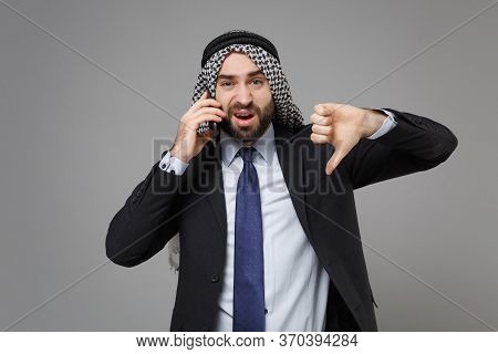 Displeased Arabian Muslim Businessman In Keffiyeh Kafiya Ring Igal Agal Black Suit Isolated On Gray 