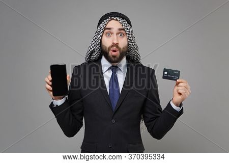 Shocked Arabian Muslim Businessman In Keffiyeh Kafiya Ring Igal Agal Suit Isolated On Gray Backgroun