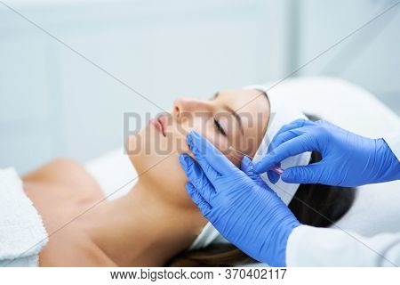Beautiful young woman getting polydioxanone thread lifting at beauty salon.