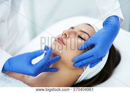 Beautiful young woman getting polydioxanone thread lifting at beauty salon.