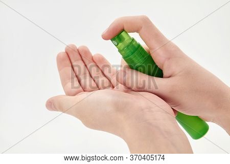 A Small Girl Hand Is Spraying Hand Sanitizer. Virus Prevention. Light Background, Closeup.