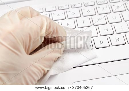 Human Hand In White Protective Glove Cleans With A Disinfectant Cloth Notebook Surface For Preventio