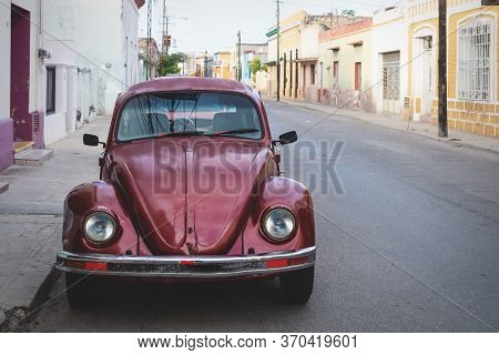 Merica, Yucatan, Mexico - 28 October 2018 - Red Oldtimer Volkswagen Beetle In The Colonial Historica