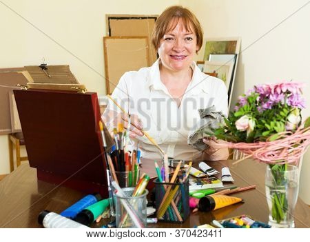 Happy Mature Woman Painting A New Picture.