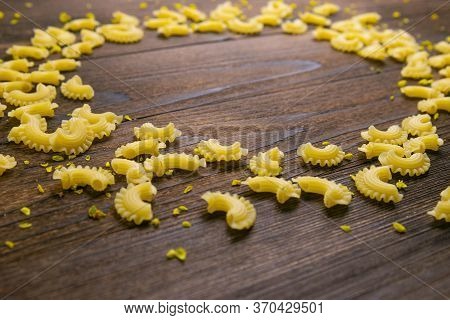 Pene Lisce Pasta In The Form Of A Circle On Dark Wooden Background. Front Views.