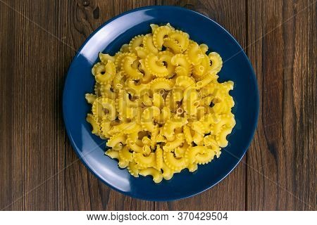 Pene Lisce Pasta In Blue Plate On Dark Wooden Background. Top Views.