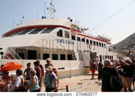 Symi, Greece - June 12, 2019: Travelers Of King Saron Passenger Catamaran Come Ashore In The Port Of