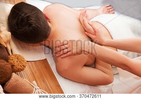 Man Procumbent With Hands Of Masseur With White Towels