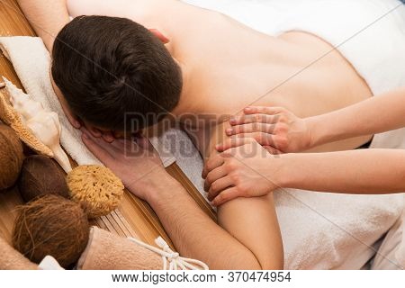 Man Procumbent With Hands Of Masseur With White Towels