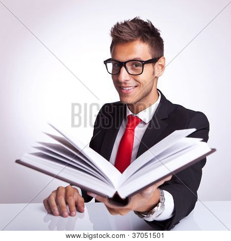 business man wearing glasses offering his book to you to read and smile
