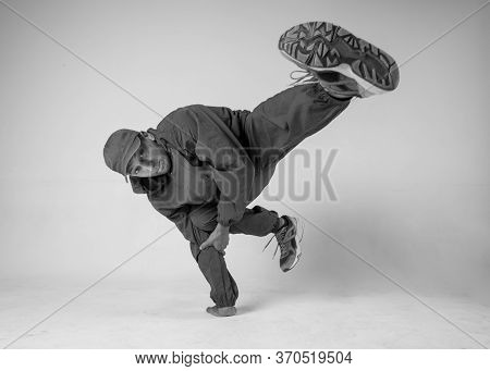 A Man Hip Hop Dancer Or Bboy Freezes In One Pose On A White Background. Bboy Doing Stylish Stunts.