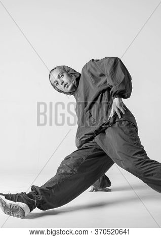 A Man Hip Hop Dancer Or Bboy Freezes In One Pose On A White Background. Bboy Doing Stylish Stunts.