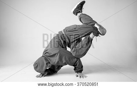 A Man Hip Hop Dancer Or Bboy Freezes In One Pose On A White Background. Bboy Doing Stylish Stunts.