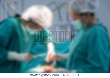 Blurred Image Background Of Medical Team Performing Surgical Operation In Operating Room. An Operati