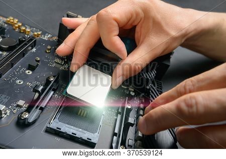 Hands Of A Technician Assembling Computer Hardware Parts, As A New Shiny Cpu Is Being Mounted Unto T