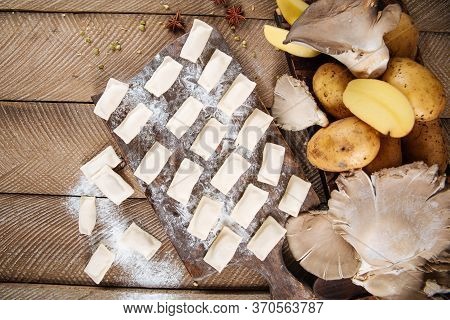Top View On Semi-finished Potato And Mushroom Dumplings Vareniki On The Wooden Background, Horizonta