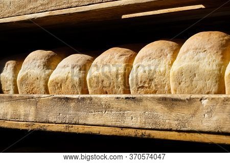 Showcase Of The Food Market With Fresh Rye Bread, Close-up. Wooden Shelves With Bread In The Shape O