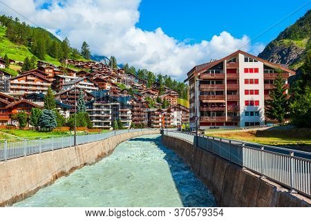 Traditional Local Houses Near The Matter Vispa River In The Centre Of Zermatt Town In The Valais Can