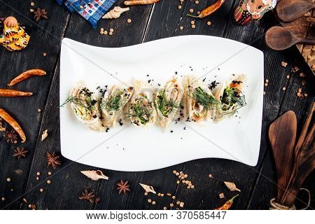 Top View On Gourmet Slapjack Rolls With Salmon Filling Black Caviar Dill Garnish On A White Plate, H